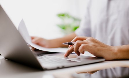 Up close photo of someone on their laptop
