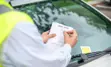 Photo of enforcement officer issuing a parking ticket
