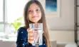 Young girl holding up a glass of drinking water