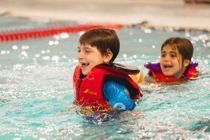 kid swimming in PFD