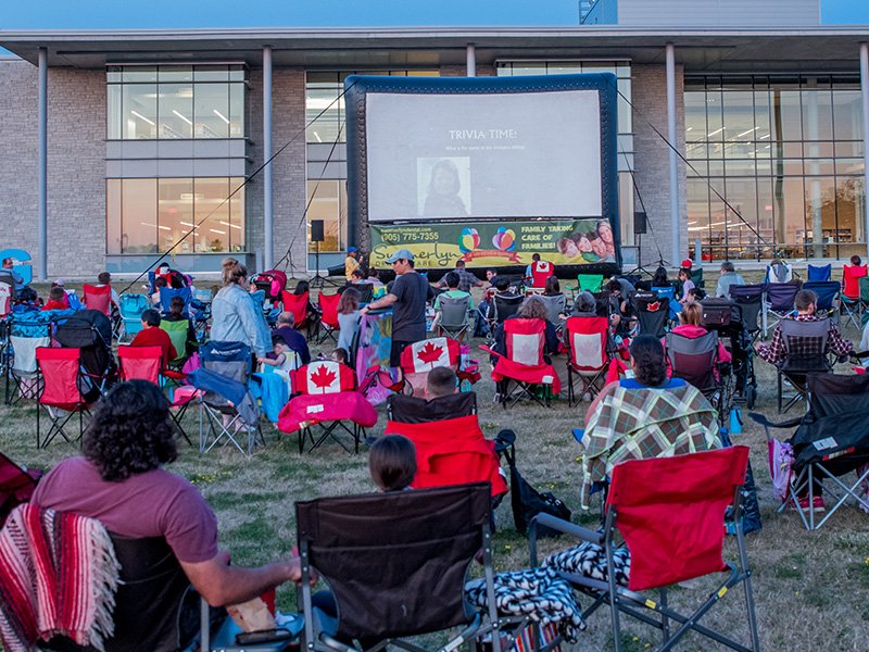 Image of community sitting in chairs watching a movie