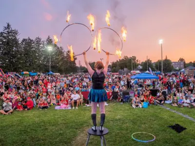 fire performer with hula hoops in front of crowd at event