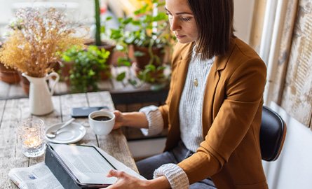 Businesswoman sitting at a coffee shop using a tablet