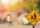 Crossing sign in front of sunny glare