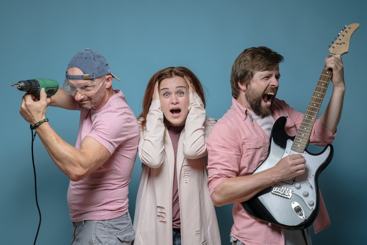 Man with drill, Woman with hands over ears, man with guitar