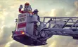 Photo of Sparky and a firefighter standing in the bucket of an erected firetruck ladder