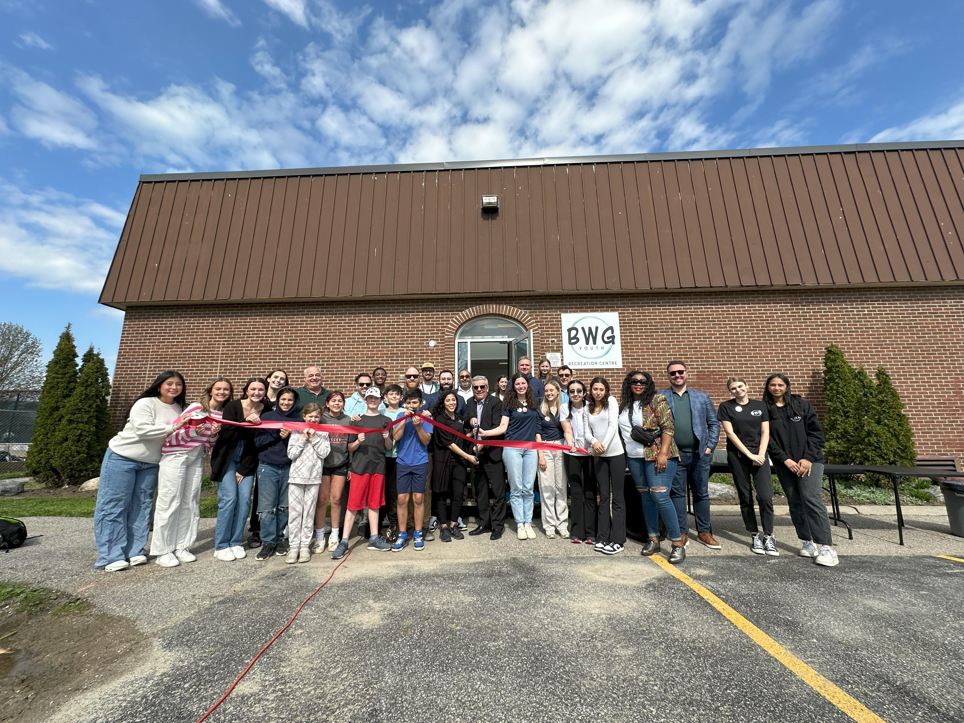 BWG Town Council, staff, and community youth cutting the ribbon outside of the New Youth Recreation Centre