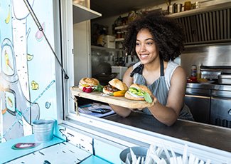 Food truck owner serving food to a customer