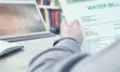 Photo of a person holding up a sample water bill